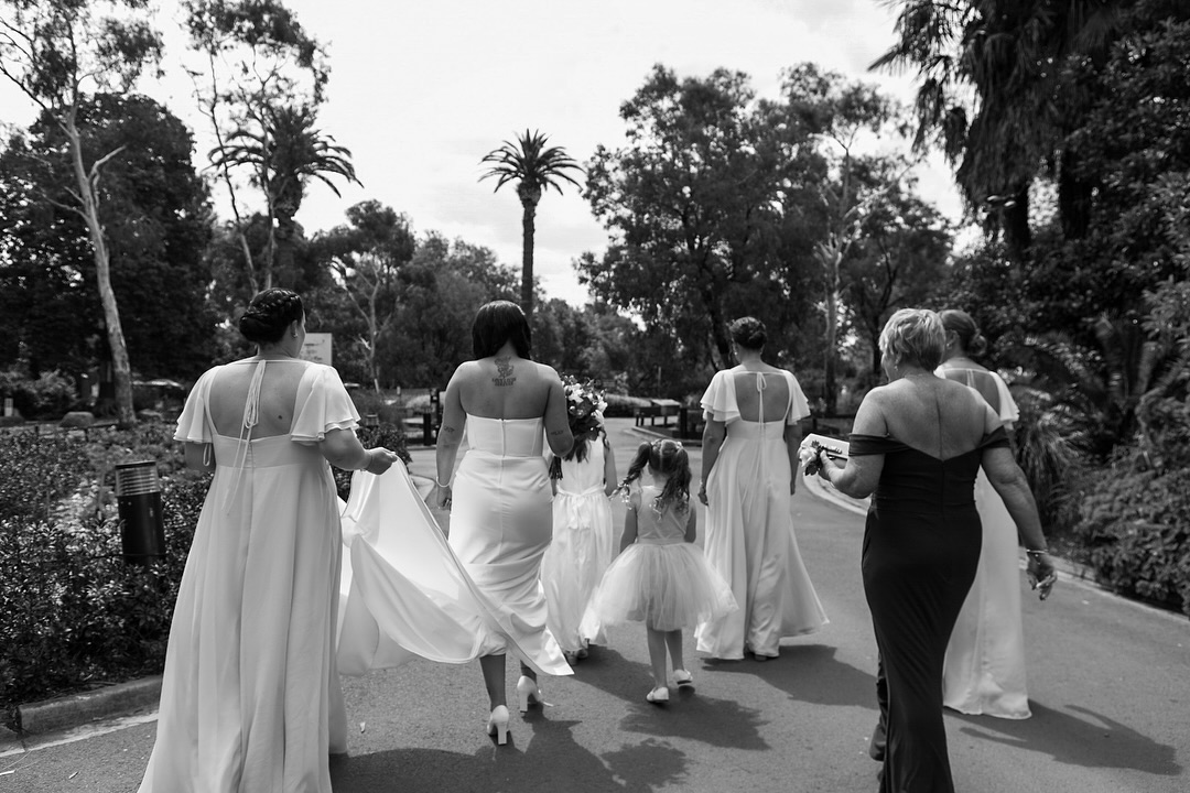 Bridal party walking away down a garden path