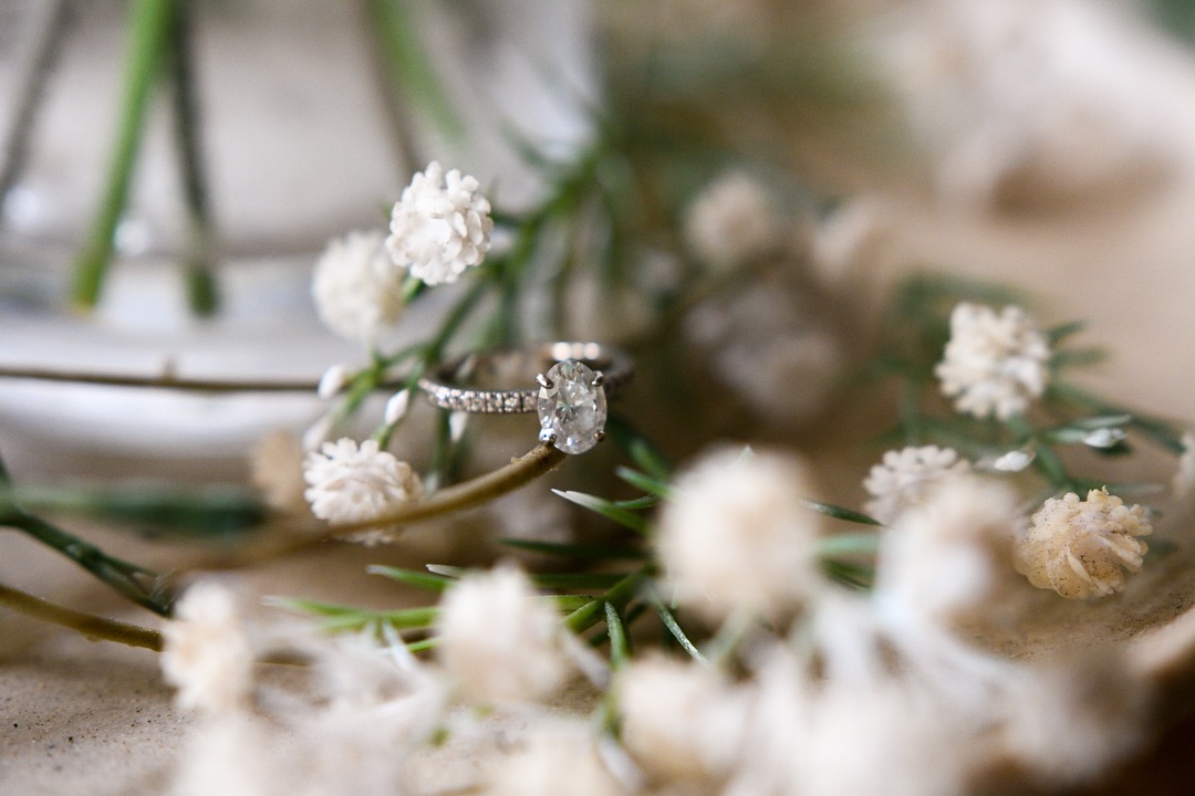 Engagement ring resting among dried flowers