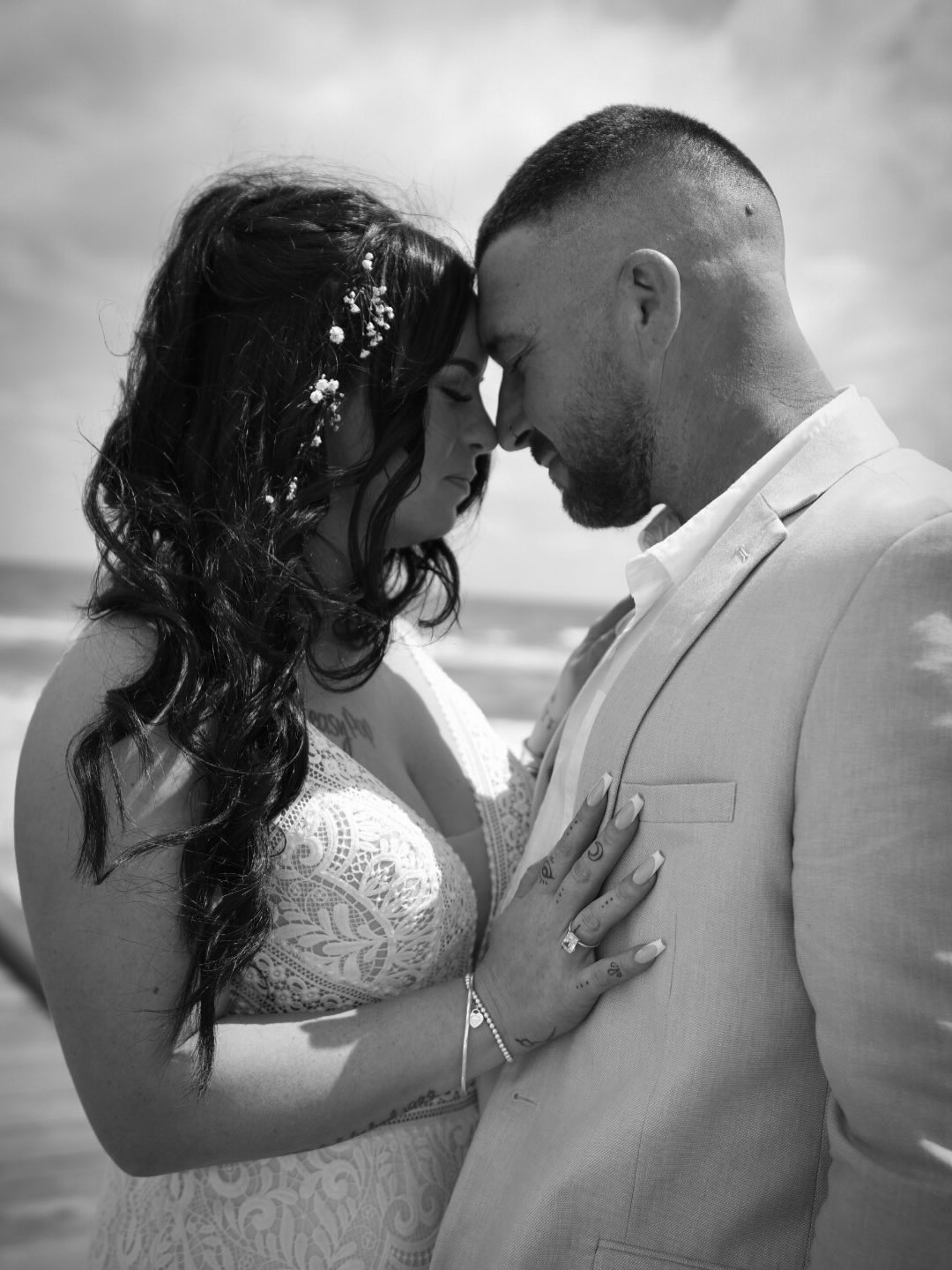 Couple forehead to forehead on the beach, black and white